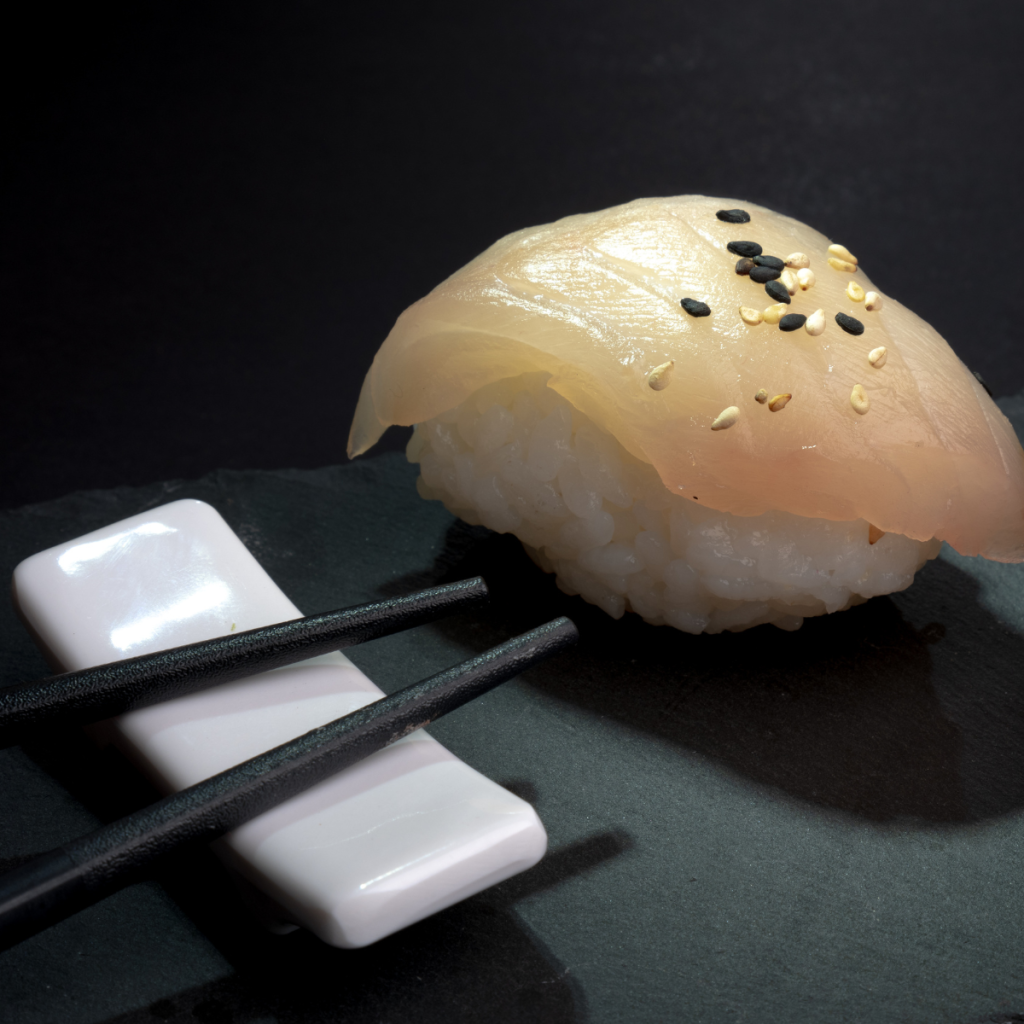 Visuel branding réalisé pour O’Sushi avec photographie produit d’un sushi mise en scène de manière élégante, exemple de réalisation en communication 360° à Clermont dans le cadre des services de communication à Clermont-Ferrand proposés par Clap Agency.